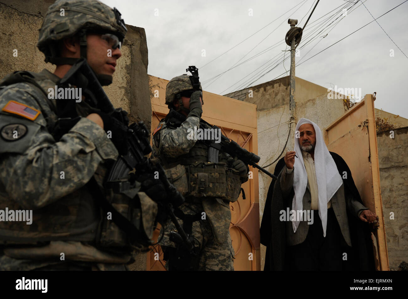 U.S. Army 1st Lt. Jeremy Glossen left and Staff Sgt. Gary Pearson center of Ironhawk Troop, 3rd Squadron, 3rd Armored Cavalry Regiment from Fort Hood, Texas, stop to visit with a local Iraqi man during a patrol in the Al Qirwan neighborhood of Mosul, Iraq, Dec. 24, 2008.   U.S. Air Force  Staff Sgt. JoAnn S. Makinano Stock Photo