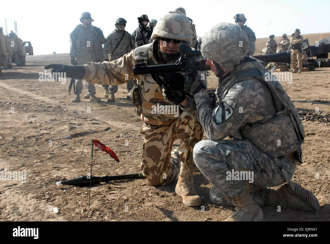 Spc. Justin Dreyer from the Special Troops Battalion, 4th Brigade Combat Team, 1st Cavalry Division, is instructed how to fire a rocket-propelled grenade launcher by a Soldier in the 341st Romanian Infantry Battalion during a cross-training event at the Bardia Firing Range near COB Adder, Iraq.  Pfc. Terence Ewings Stock Photo