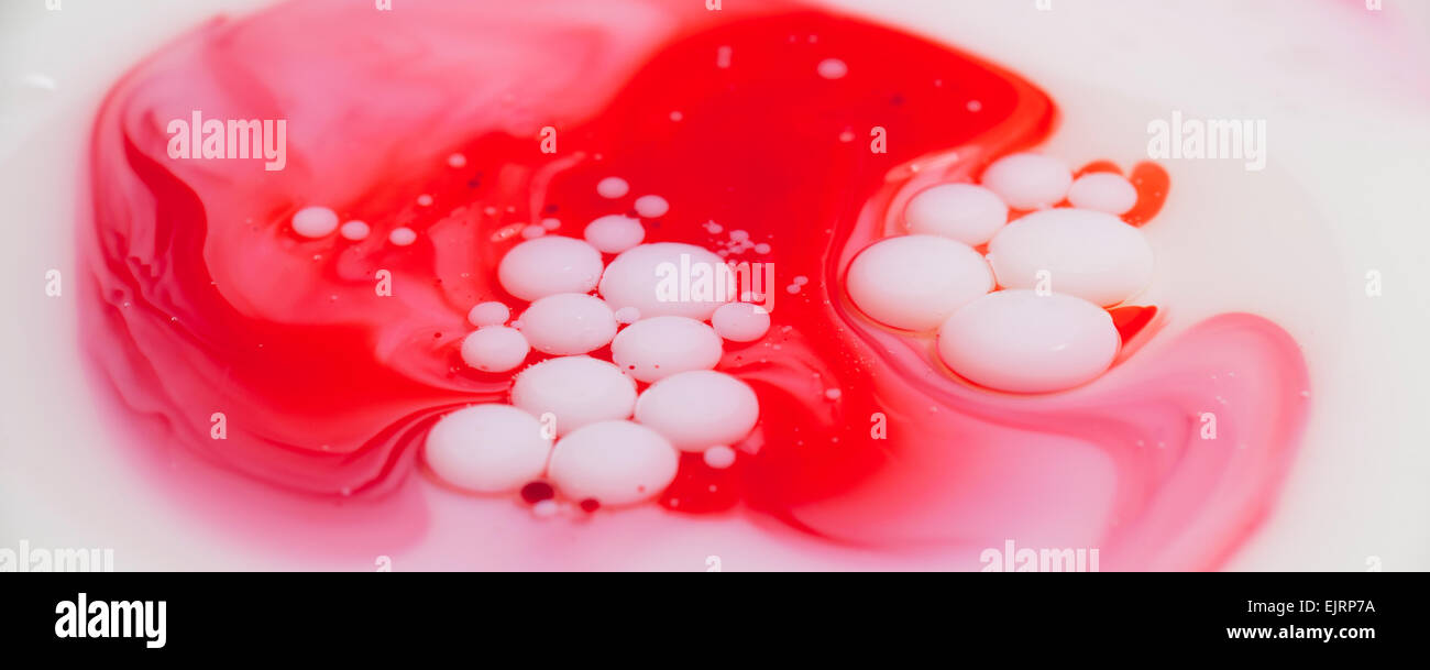 A layer of mineral oil on top of milk with milk bubbles floating above