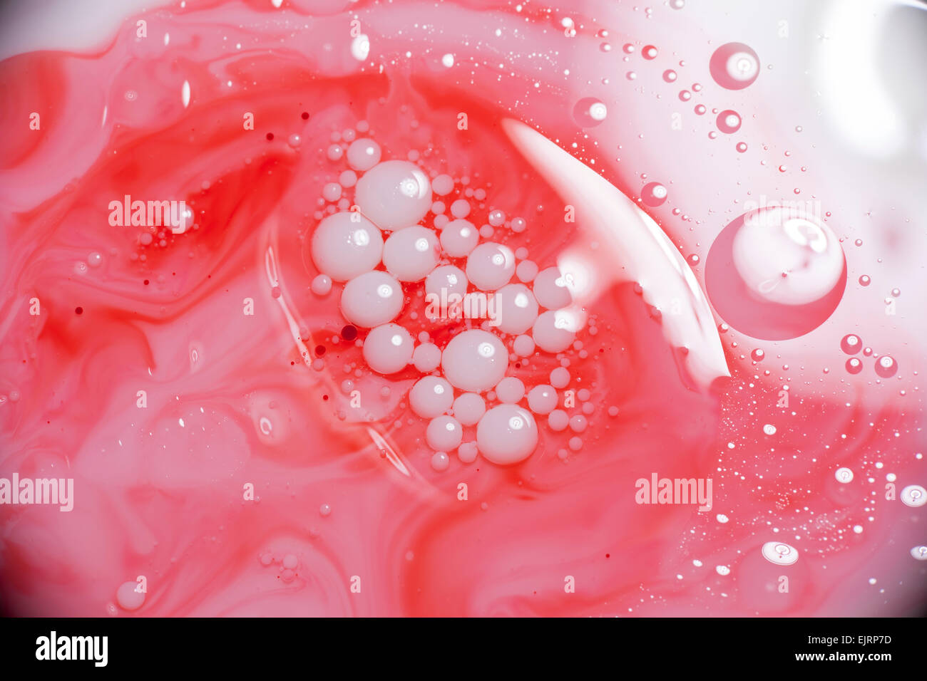 A layer of mineral oil on top of milk with milk bubbles floating above