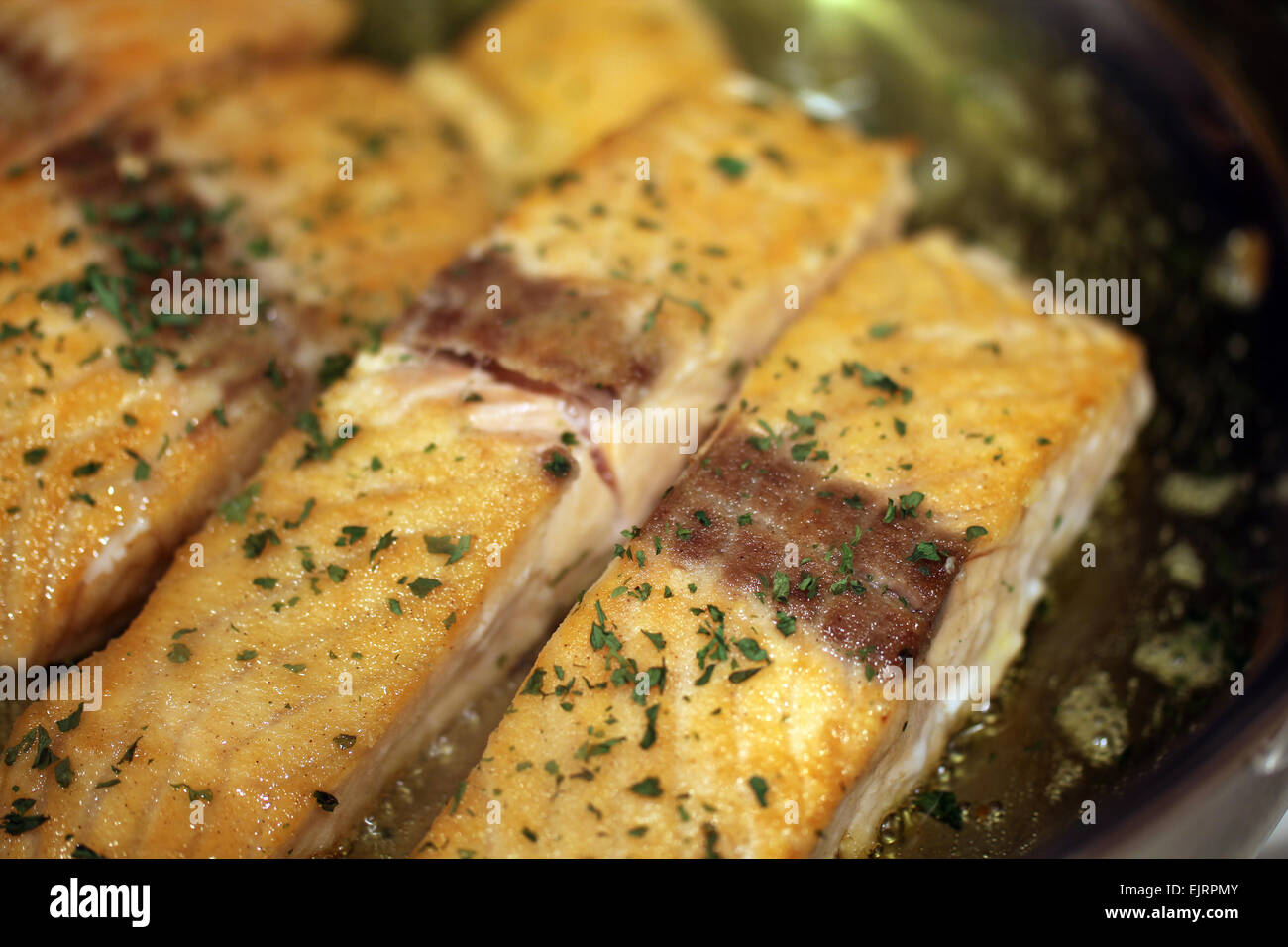 Salmon, dipped in pan searing flour, is pan seared in olive oil with