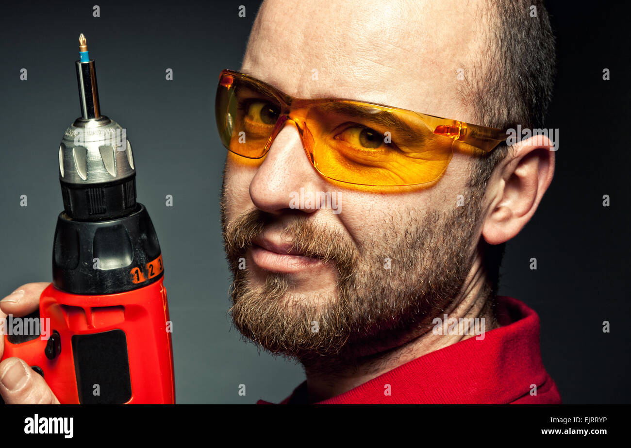 closeup of manual worker with red drill Stock Photo