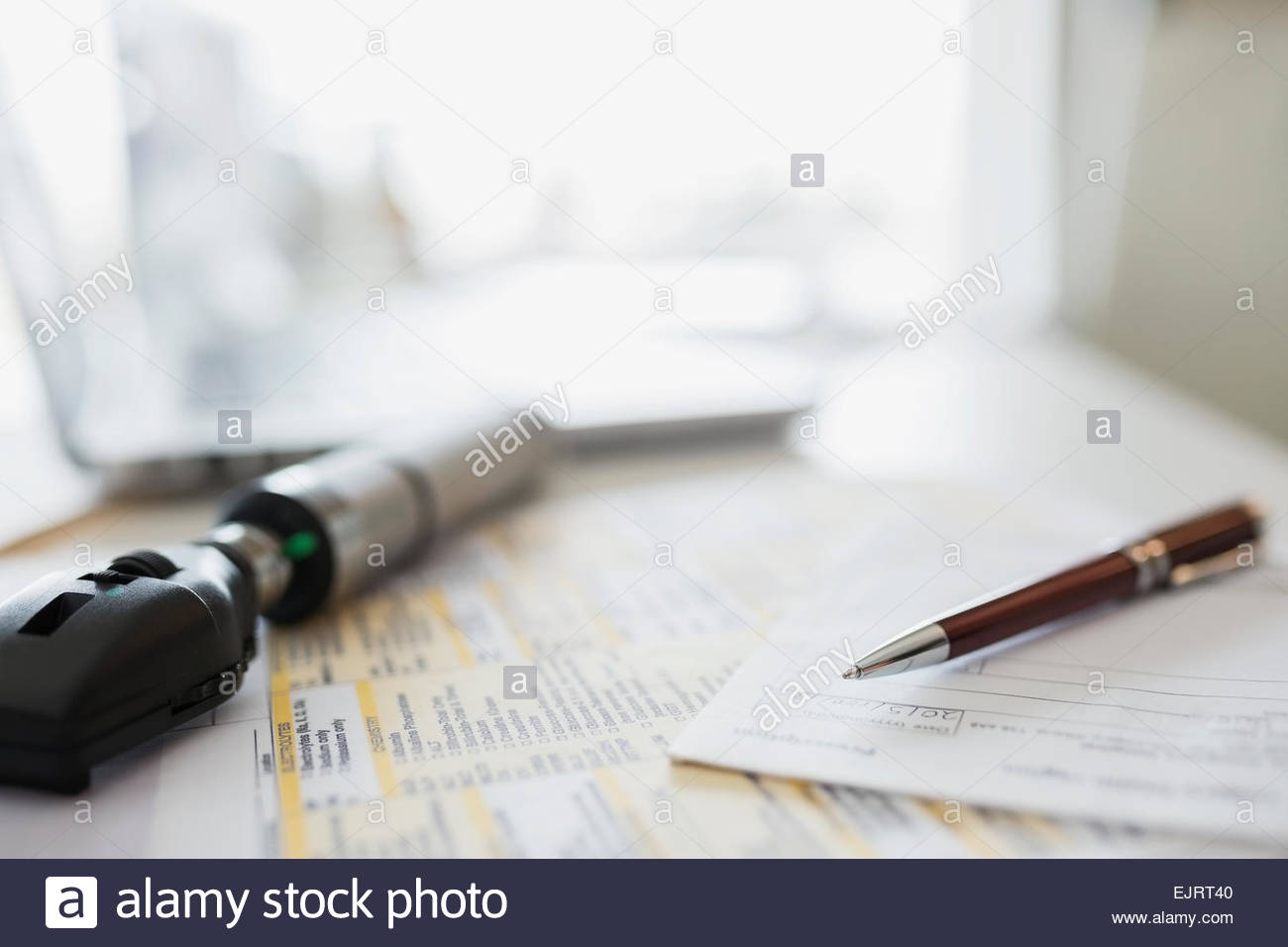 Otoscope, prescription and paperwork on doctors desk Stock Photo