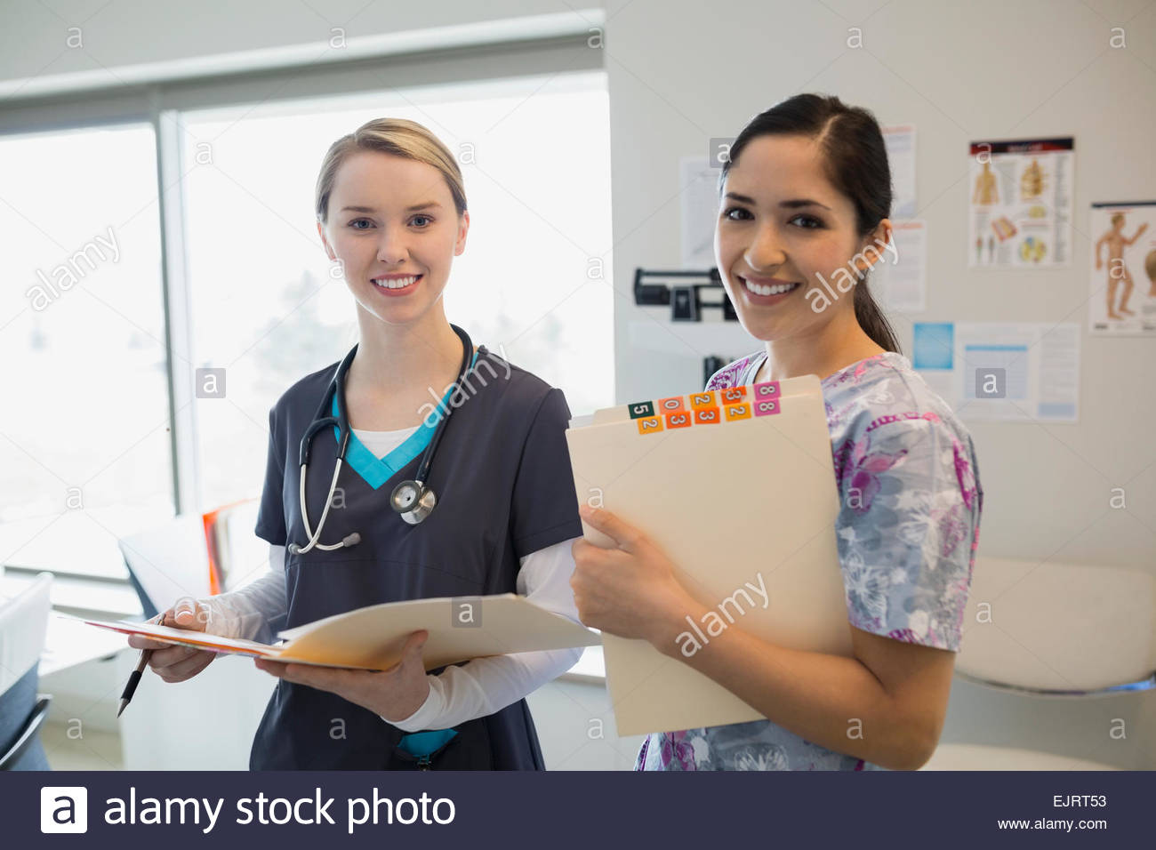 Portrait of smiling nurses with medical charts Stock Photo