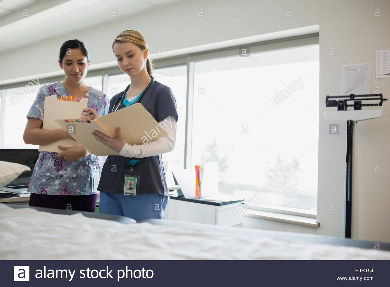 Nurses reviewing medical charts in examination room Stock Photo