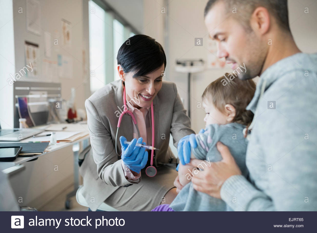 Pediatrician giving baby girl vaccination in clinic Stock Photo