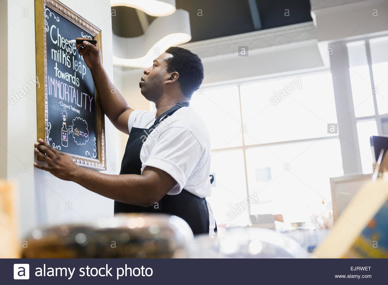 Grocery business owner writing on blackboard Stock Photo
