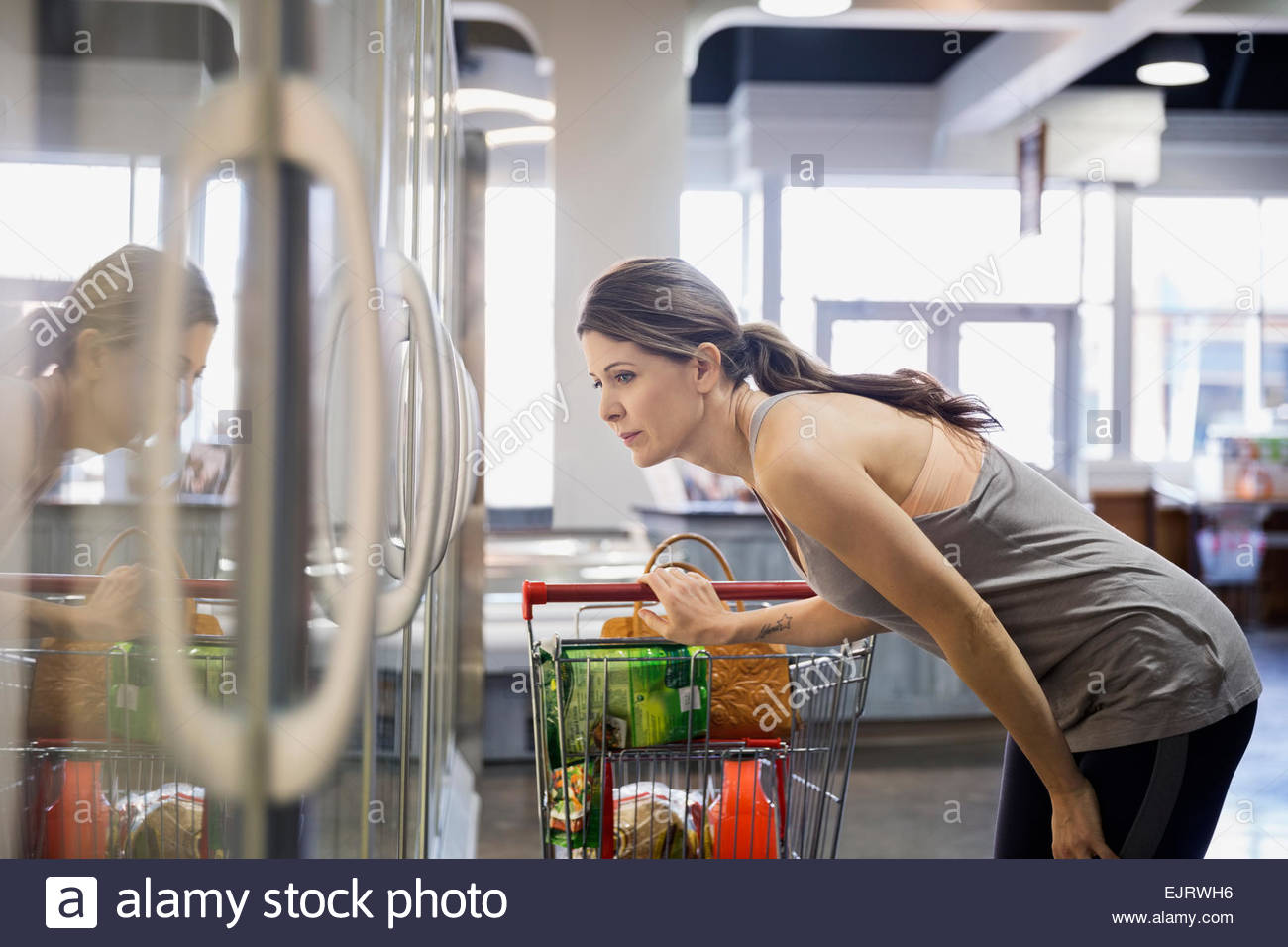 Woman shopping frozen foods in grocery store Stock Photo