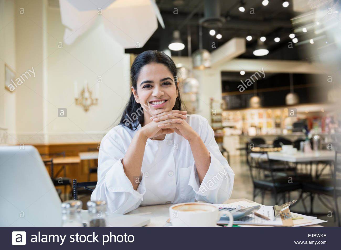 Portrait of smiling chef at laptop in cafe Stock Photo