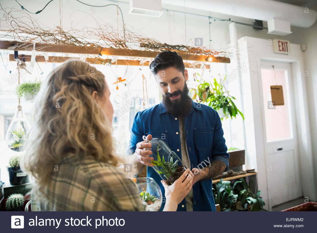 Terrarium shop owner helping customer with plants Stock Photo