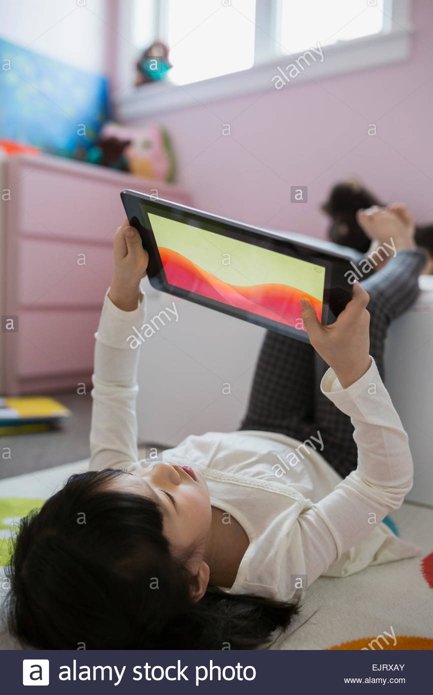 Girl using digital tablet upsidedown in bedroom Stock Photo Alamy