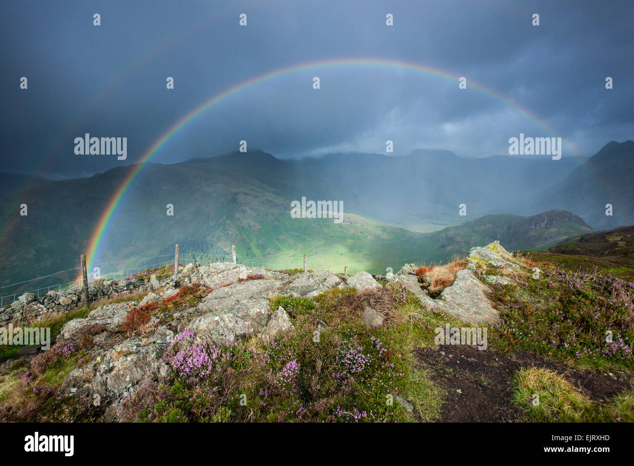 Double rainbow at the summit of Lingmoor fell on a wild camping trip in the lake district. Stock Photo