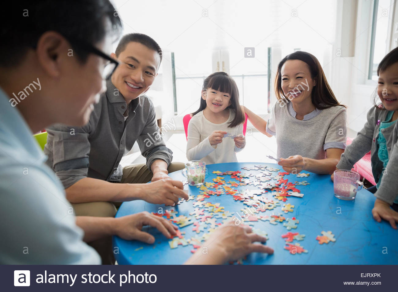 Multigeneration family assembling jigsaw puzzle Stock Photo Alamy