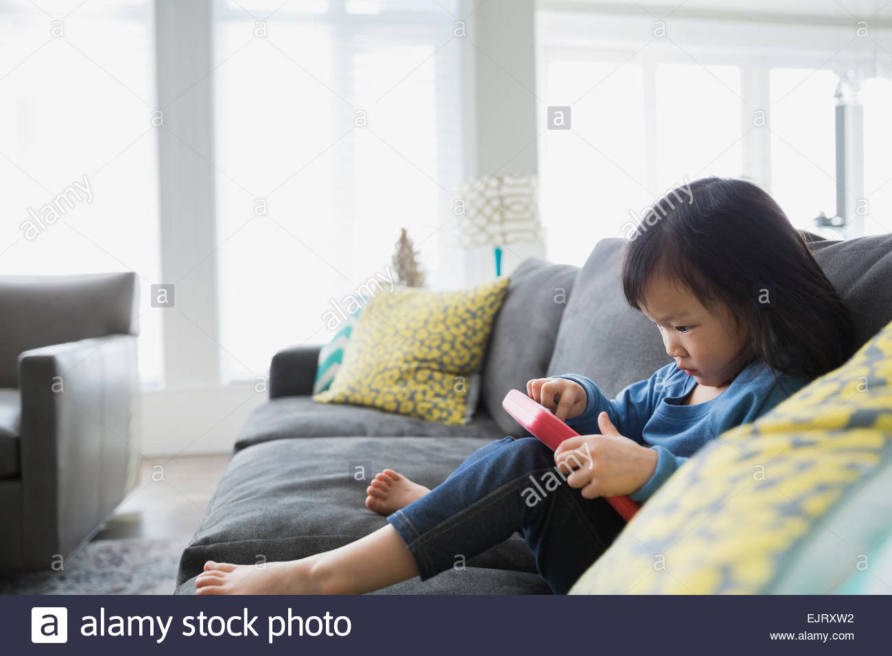 Girl sitting barefoot on sofa hi-res stock photography and images - Alamy