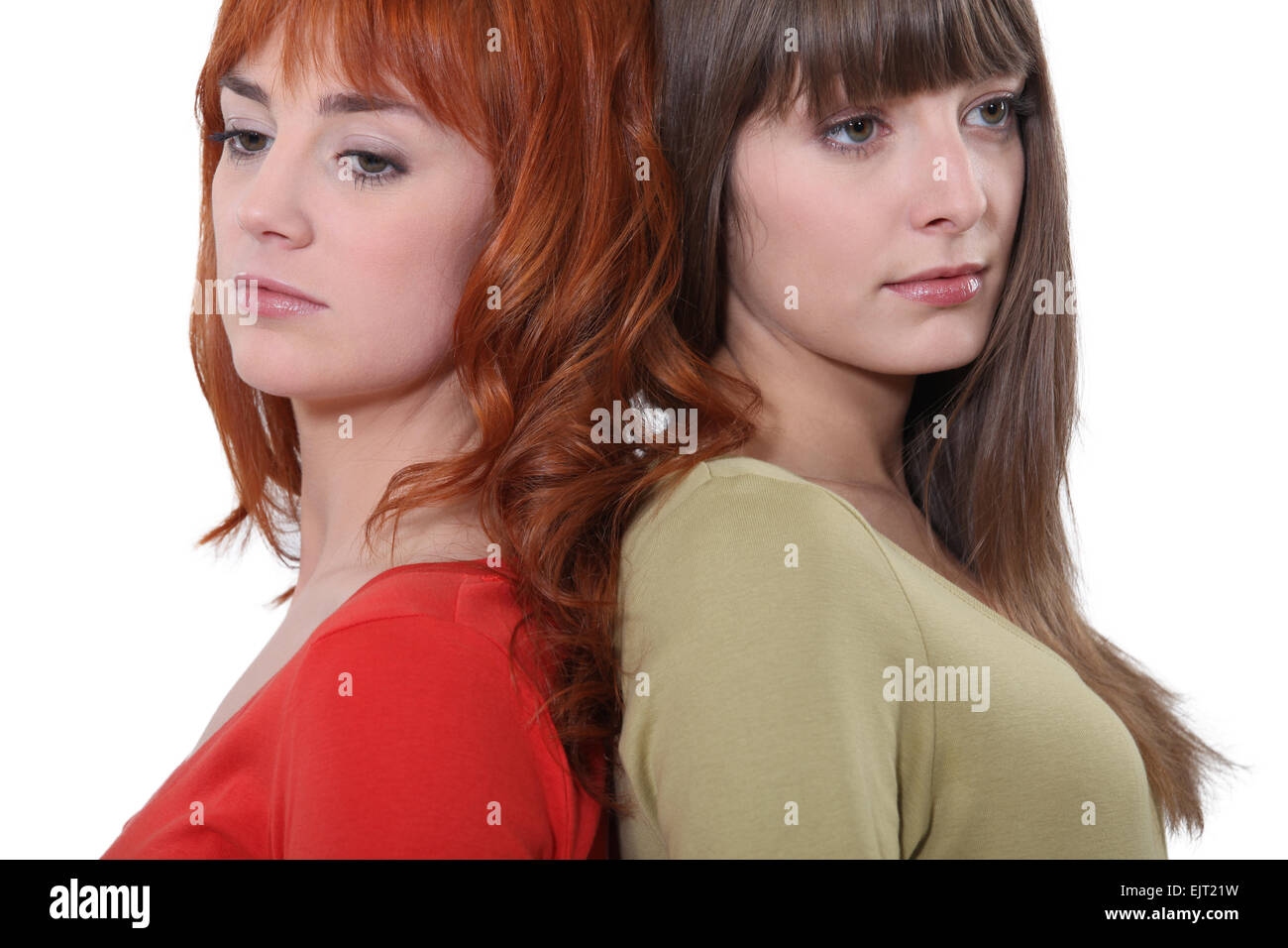 Two female friends stood back to back Stock Photo - Alamy