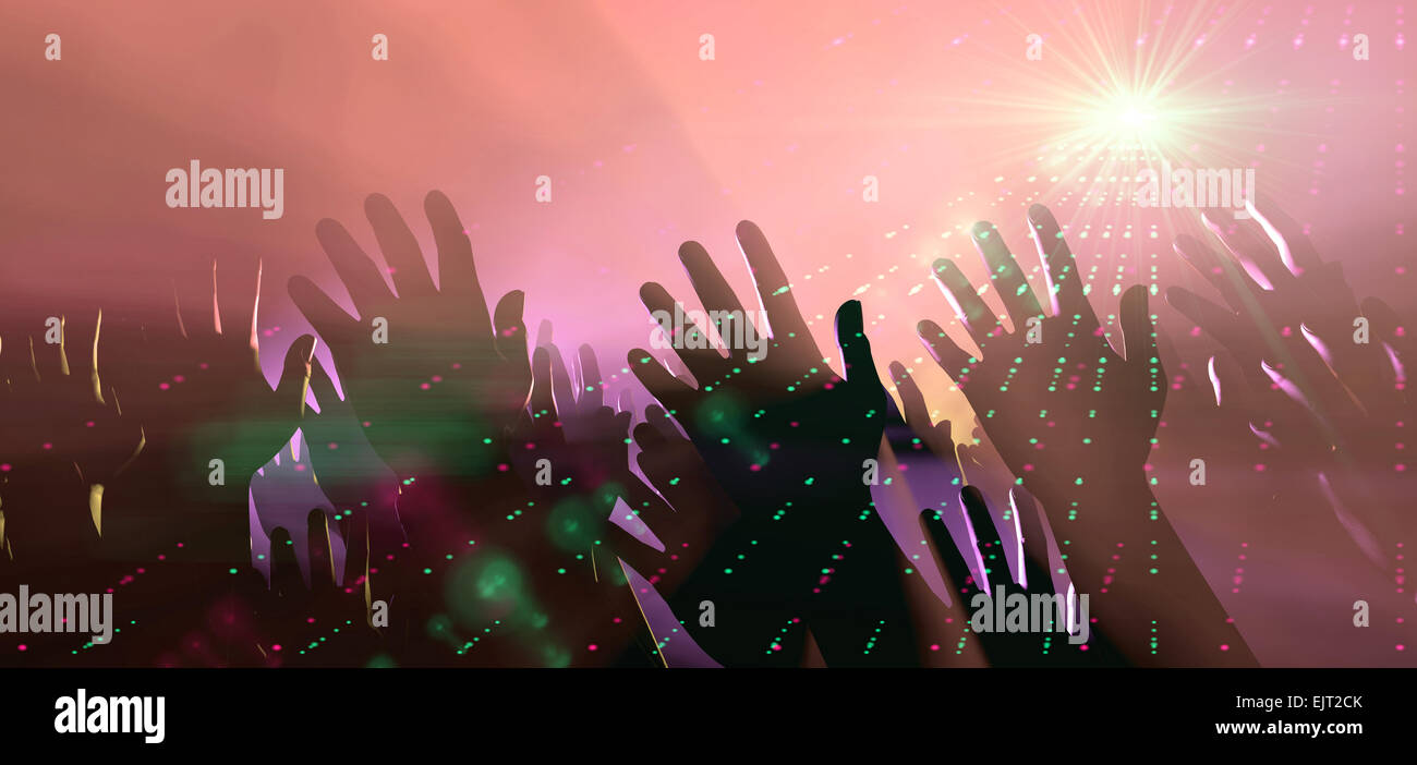 A crowd level view of hands raised from the spectating crowd interspersed by colorful spotlights and a smokey atmosphere Stock Photo