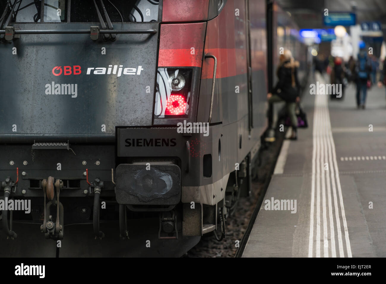 A traveler is boarding an Austrian OBB Railjet intercity train that is waiting on a platform on Zurich (Switzerland) station. Stock Photo