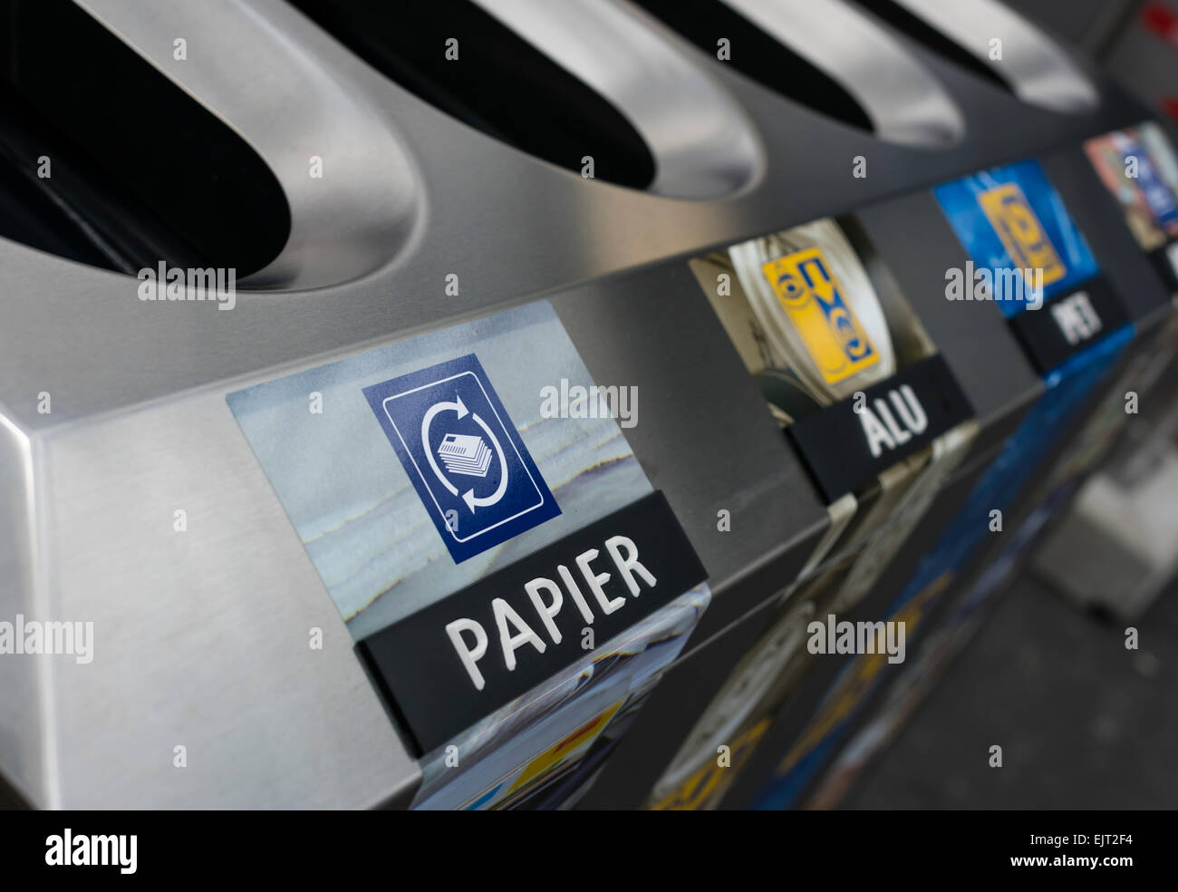 Recycle bin with separate slots for paper, aluminum and glass waste for waste separation at a platform of a Swiss train station. Stock Photo