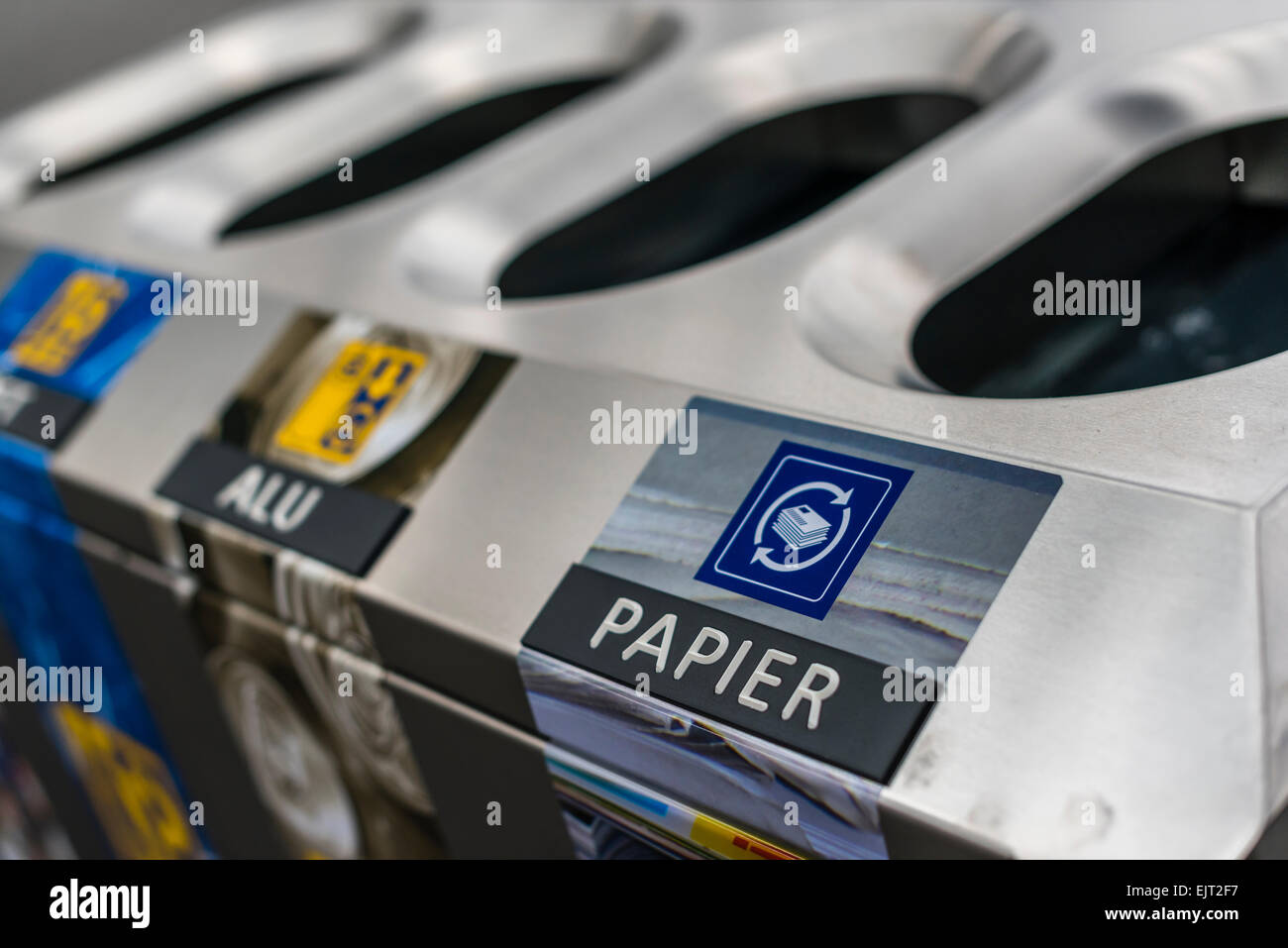 Recycle bin with separate slots for paper, aluminum and glass waste for waste separation at a platform of a Swiss train station. Stock Photo