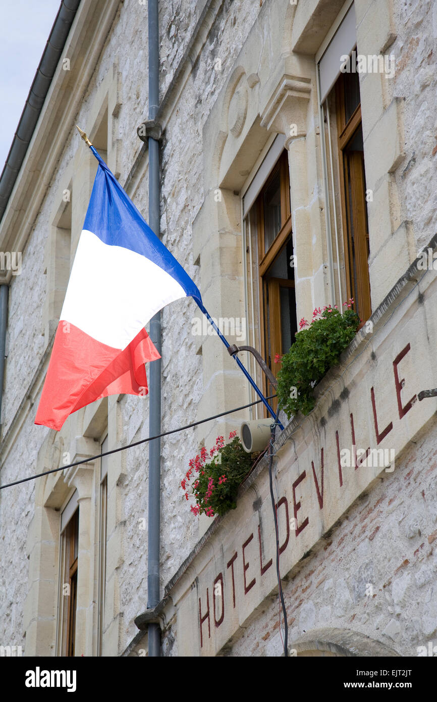 Close-up of the front facade of the Town Hall in Tournon-d'Agenais, France, with the tricolore flying from the wall mounted flag Stock Photo