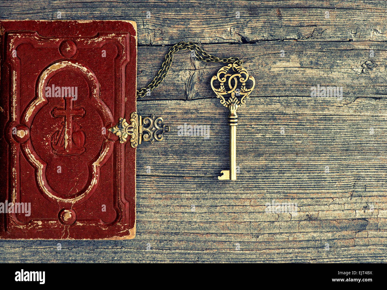 Antique bible book and golden key on wooden background. Vintage still life Stock Photo