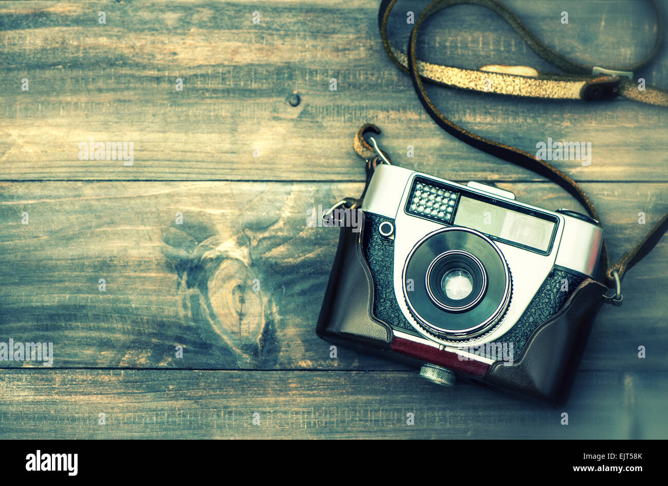 Old film camera on wooden background. Top view. Vintage style toned picture with lens blur Stock Photo
