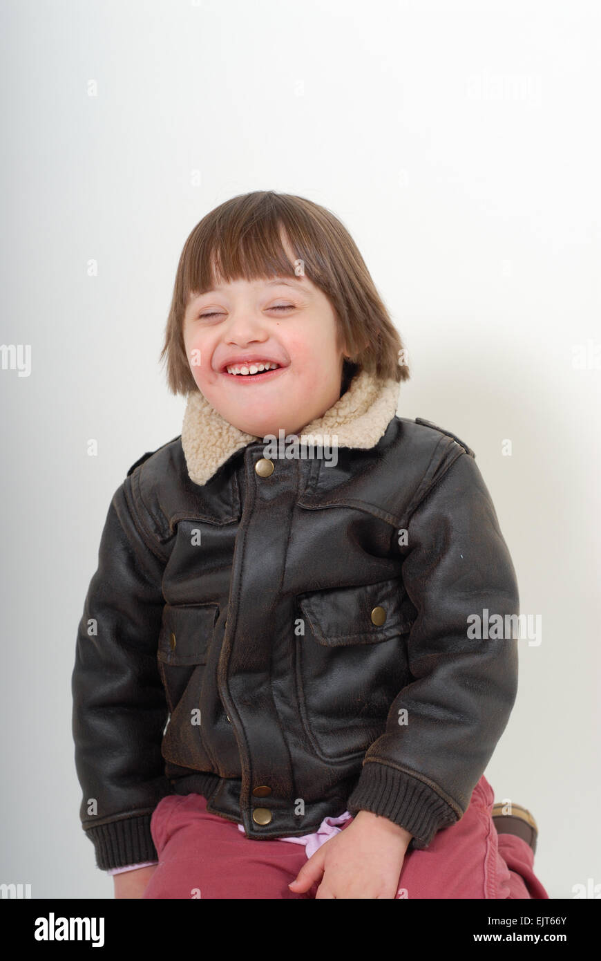 Boy with down syndrome smiling, isolated on white background. Stock Photo