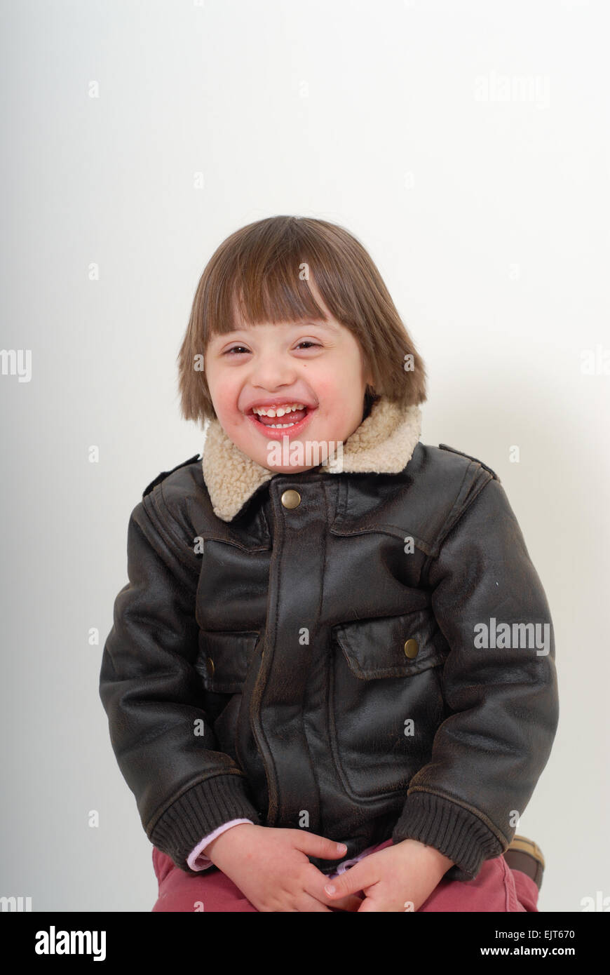 Boy with down syndrome laughing. Isolated on white background. Stock Photo