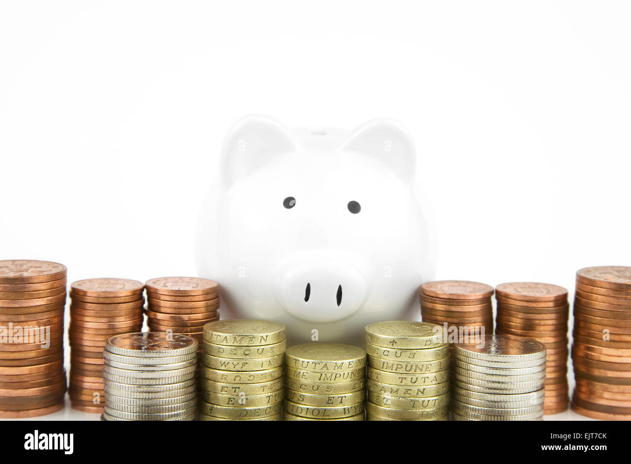 White Piggy bank With British Coins stacked in front Stock Photo - Alamy