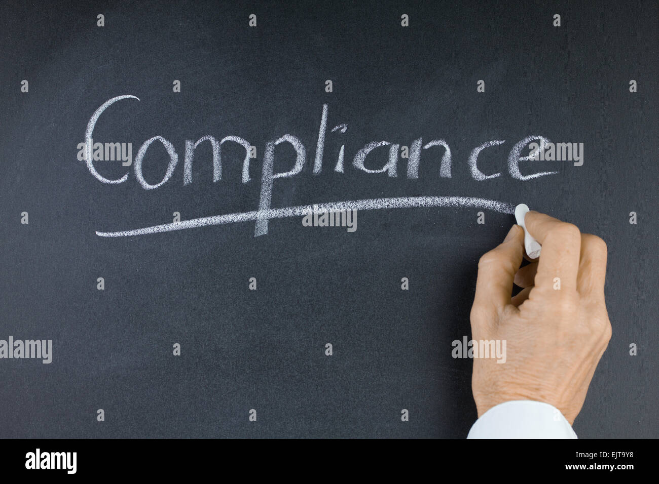 Word Compliance on Blackboard with Hand and Chalk Stock Photo