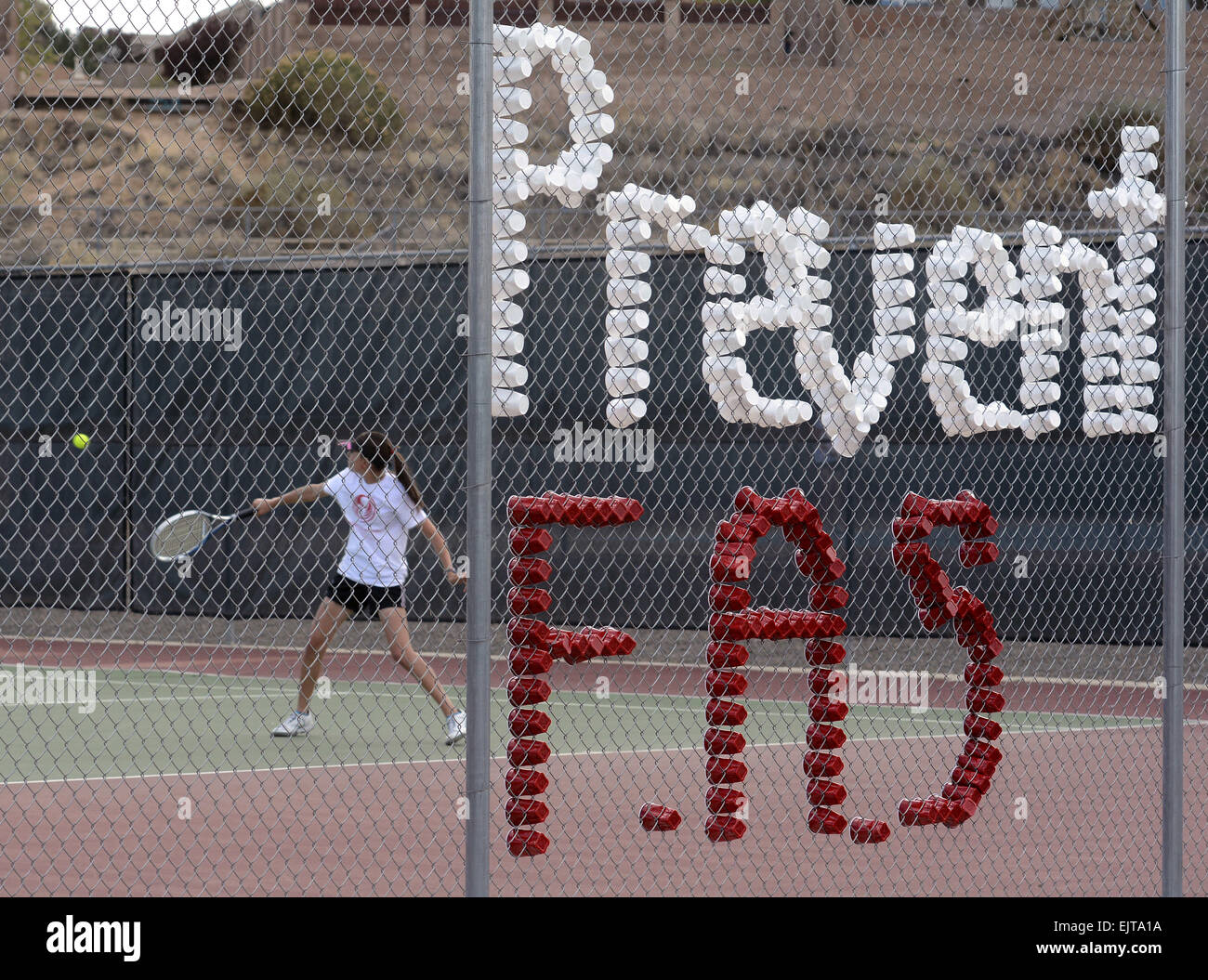 Usa. 31st Mar, 2015. Sports -- The Cibola girls tennis match against Cleveland was used to promote awareness for Fetal Alcohol Syndrome on Tuesday, March 31, 2015. Cibola's Samantha Lambrecht returns serve behind the cups spelling out the FAS message. © Greg Sorber/Albuquerque Journal/ZUMA Wire/Alamy Live News Stock Photo