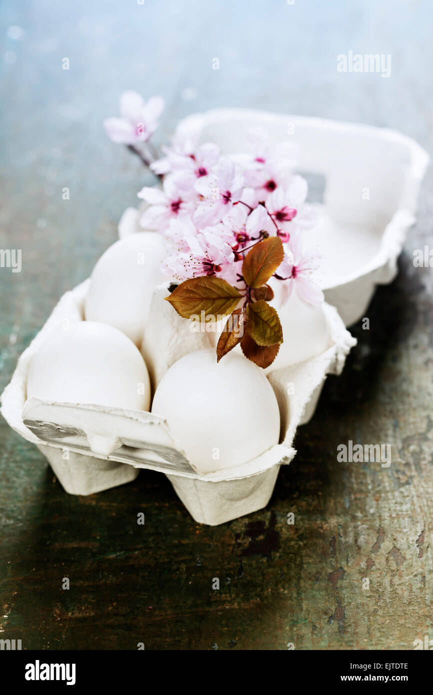 Easter eggs and spring cherry blossoms on wooden table Stock Photo