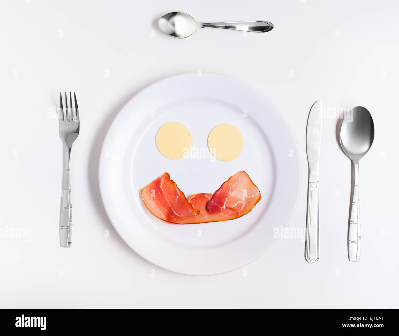 fun food, smiley face from cheese and ham on a plate with cutlery Stock Photo