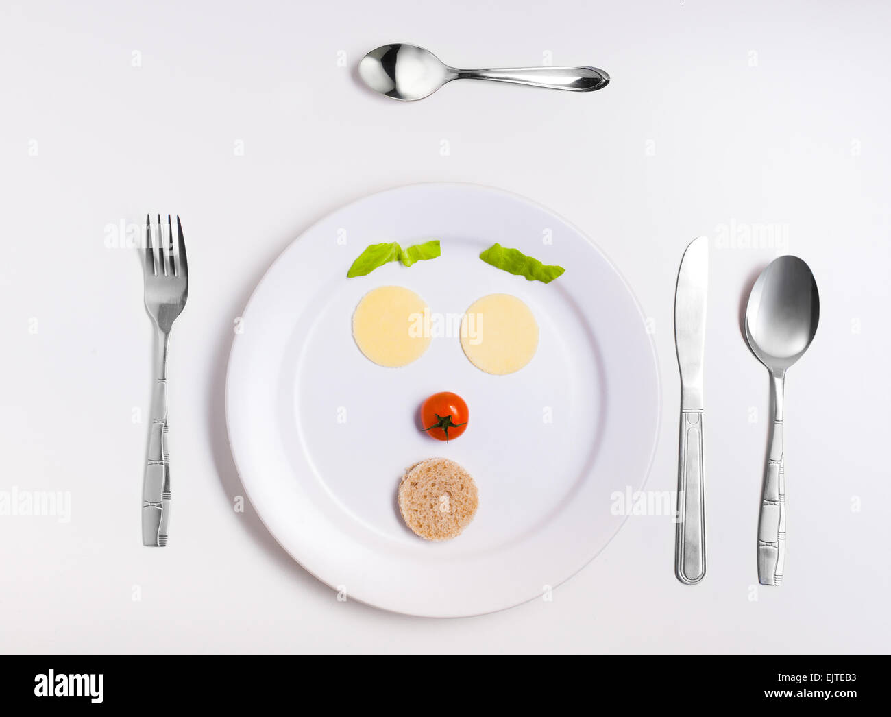 emoticon food, made from cheese, tomatoes, bread on a plate with cutlery Stock Photo