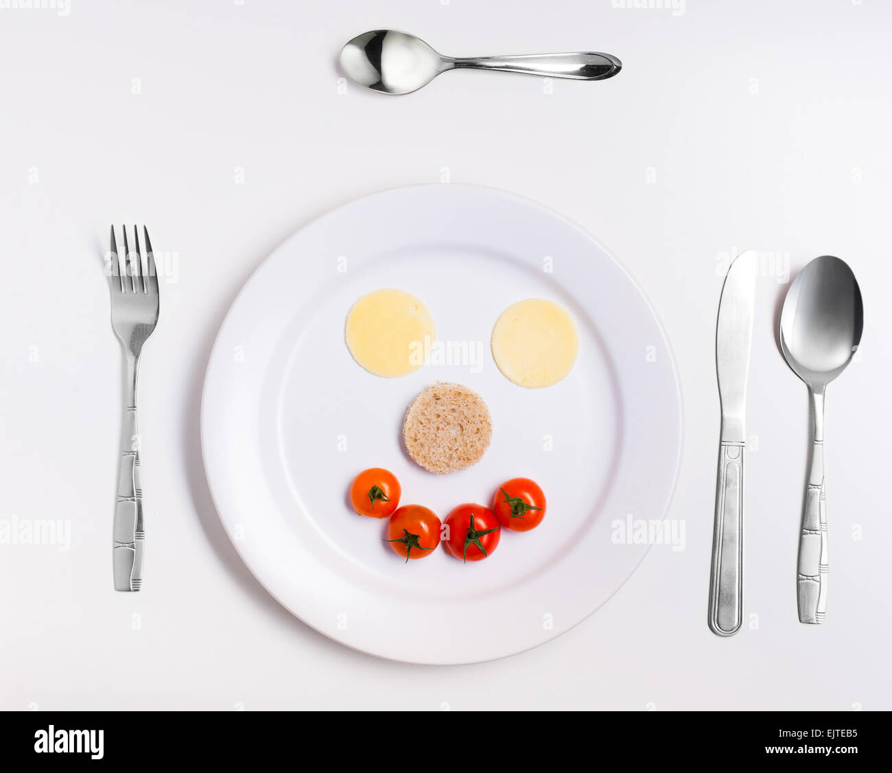 fun emoticon food, made from cheese, tomatoes, bread on a plate with cutlery Stock Photo
