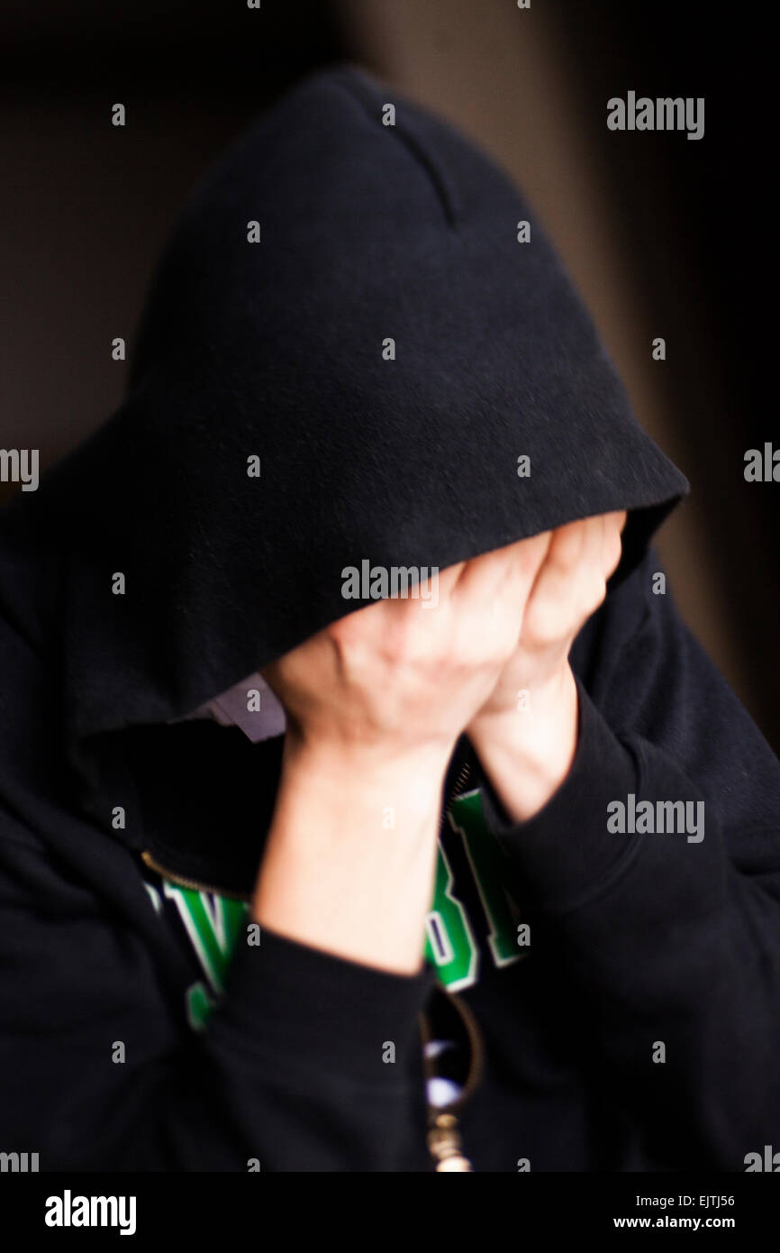 Man covering face with hands at home Stock Photo