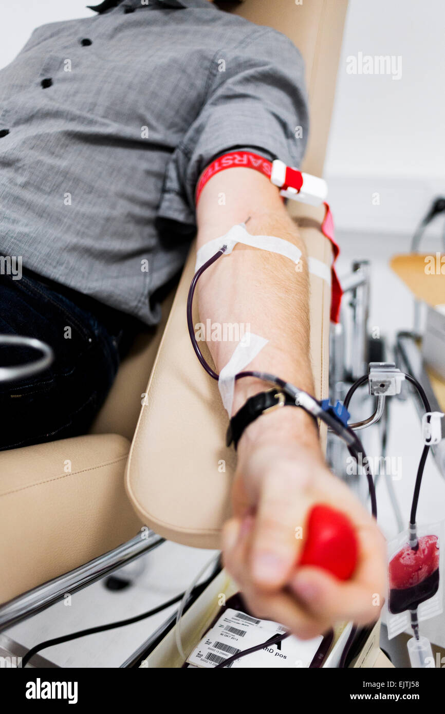 Midsection of male patient donating blood in hospital Stock Photo