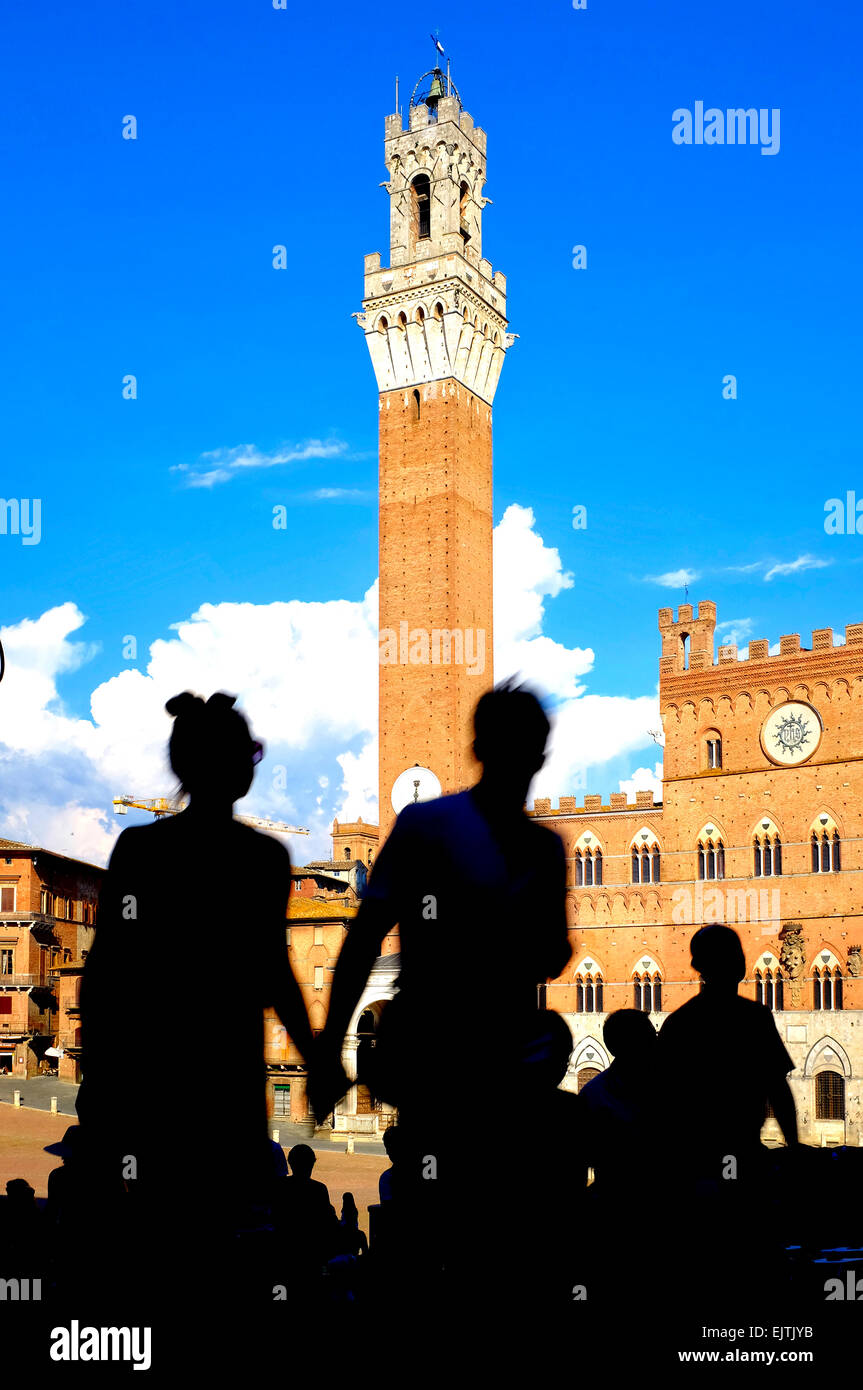 Silhouettes of tourists in front of the Palazzo Publico and Torre del Mangia, Siena Italy Stock Photo