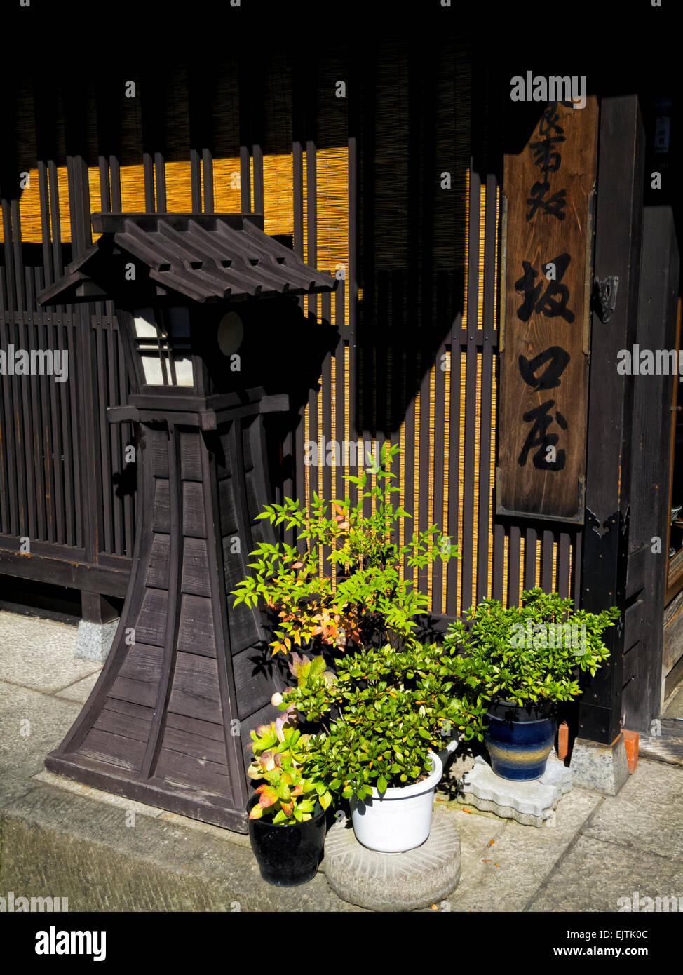 Lamp, plants and wooden building: traditional Edo period style in Japan. old Japanese style architecture; traditional wooden lamp; Takayama Stock Photo