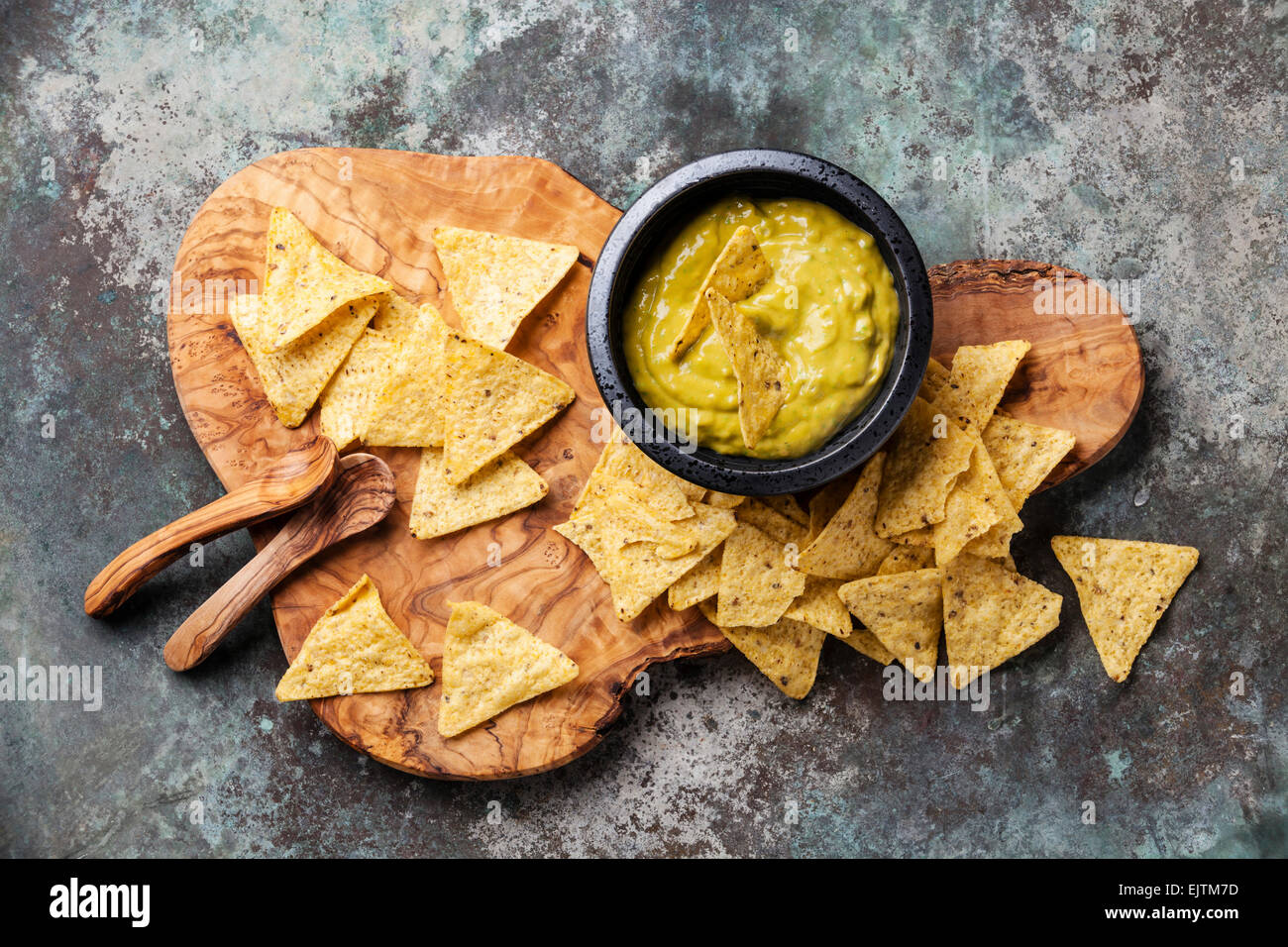 Fresh guacamole dip with nachos chips on olive wood background Stock Photo