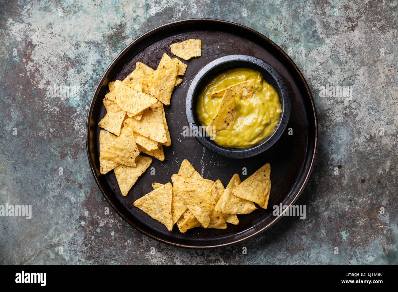 Fresh guacamole dip with nachos chips on metal background Stock Photo