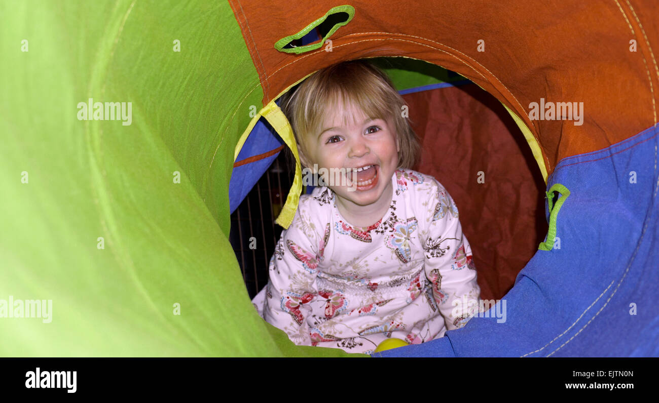 smiling toddler in play tunnel Stock Photo