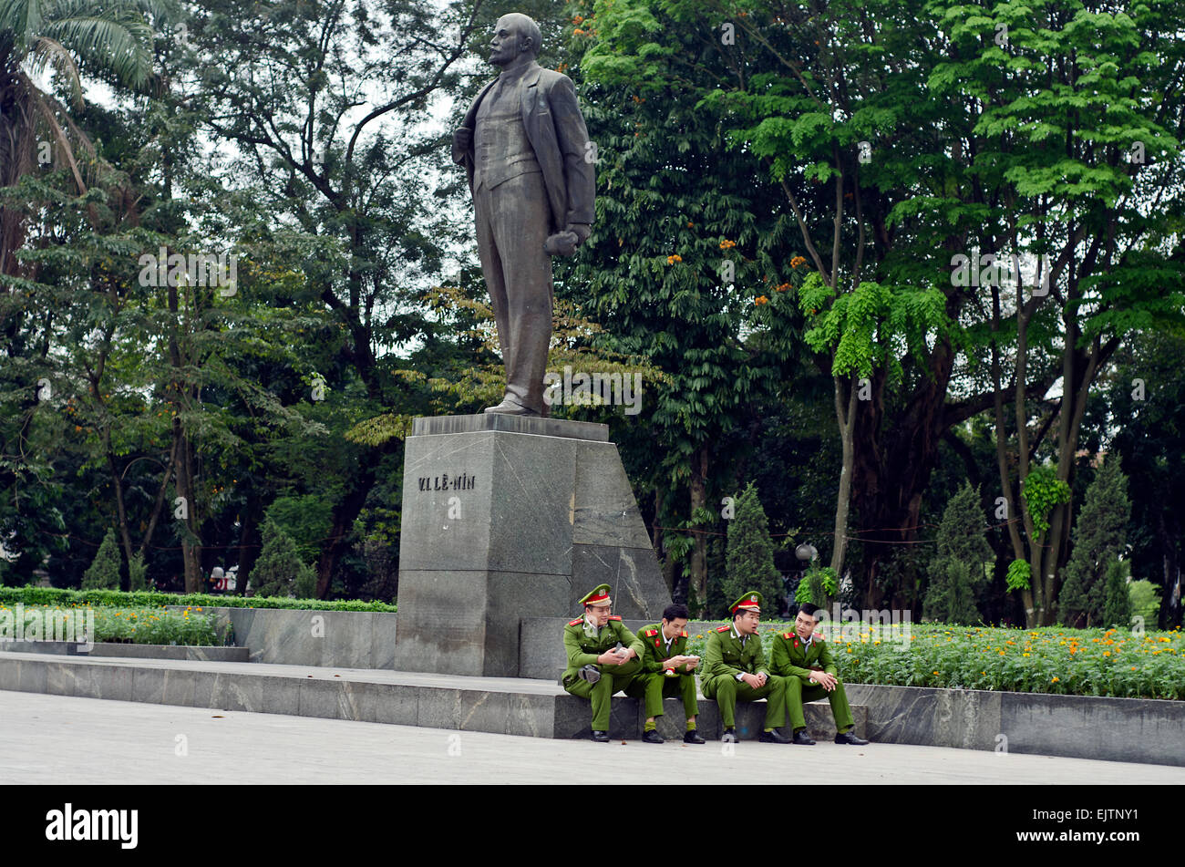 Soldiers sitting  next to Vladimir Lenin statue, Lenin park, Hanoi, Vietnam Stock Photo