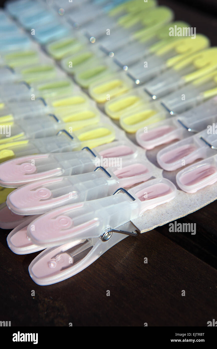 New soft grip plastic clothes pegs clipped on cardboard Stock Photo