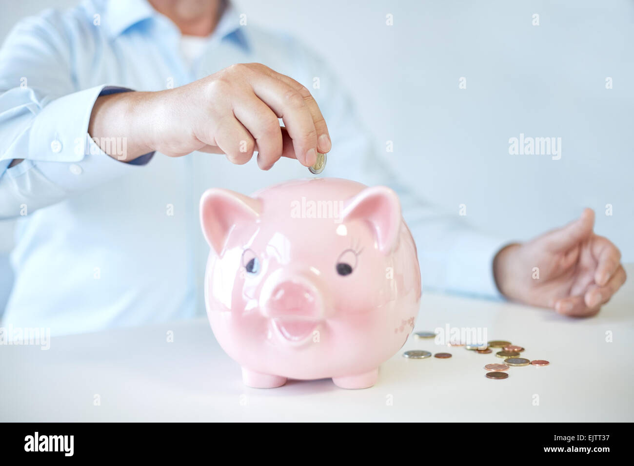 close up of old man putting coins into piggybank Stock Photo - Alamy