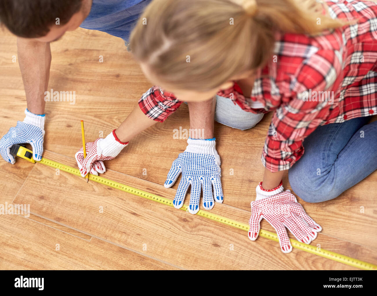 happy couple with ruler measuring parquet board Stock Photo - Alamy