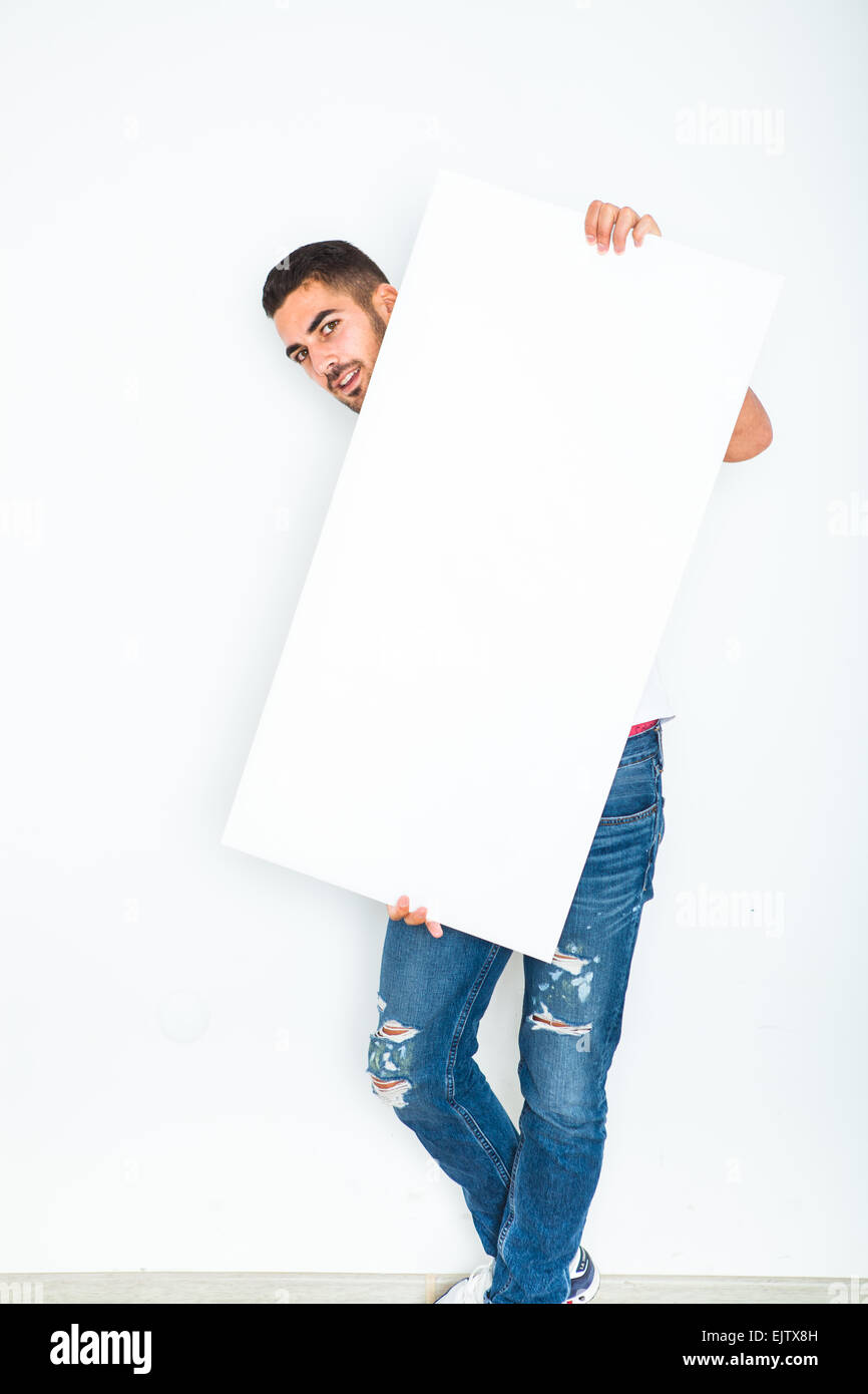 Young handsome man casual dressed smiling and showing a blank panel on white background Stock Photo