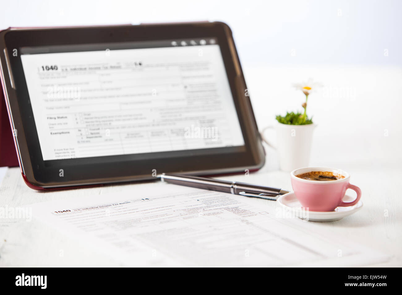 preparing 1040 tax form with a cup of coffe and a tablet Stock Photo