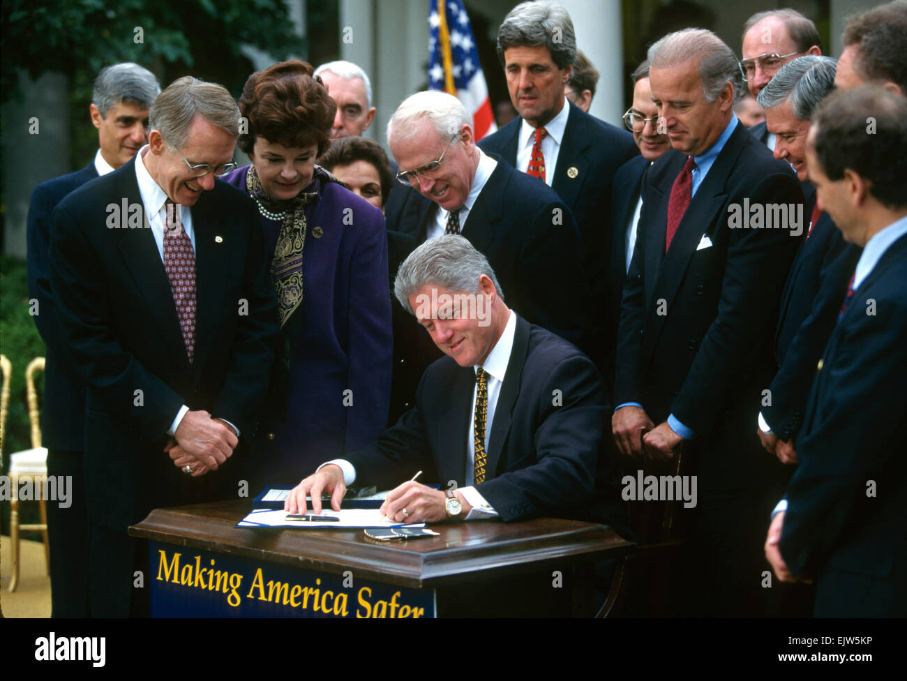 US President Bill Clinton signs into law the Crime bill during a ceremony on the South Lawn of the White House October 3, 1996 in Washington, DC.  Senators Harry Reid, Dianne Feinstein, John Kerry and Joe Biden look on. Stock Photo