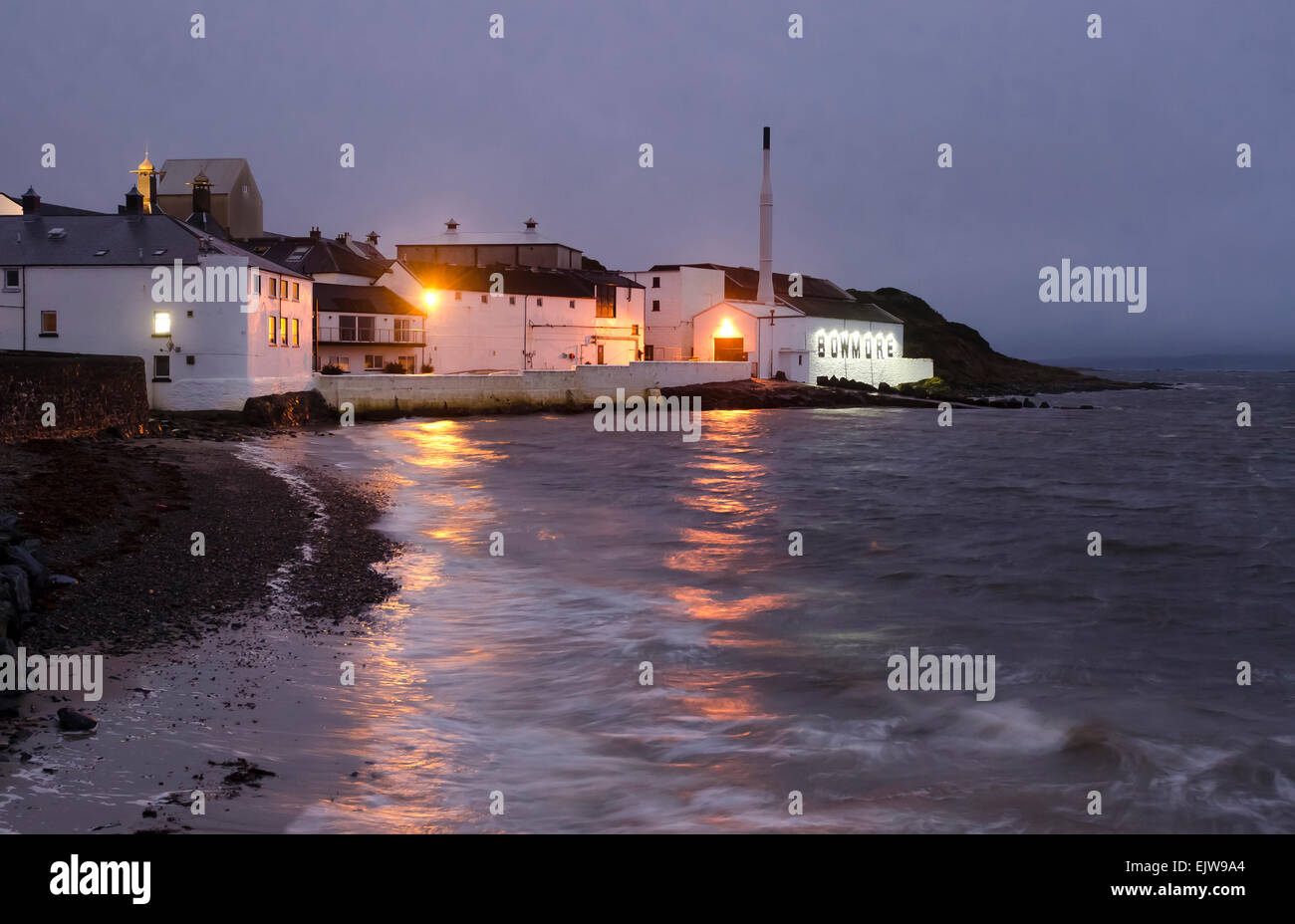 bowmore distillery at dusk with shoreline and lapping seawater Stock Photo